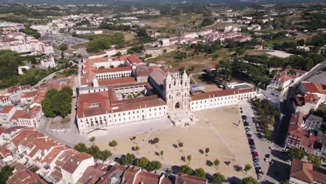 Spectacular-aerial-pan-shot-of-the-front-building-facade-of-Alcobaça-monastery-in-central-Portugal