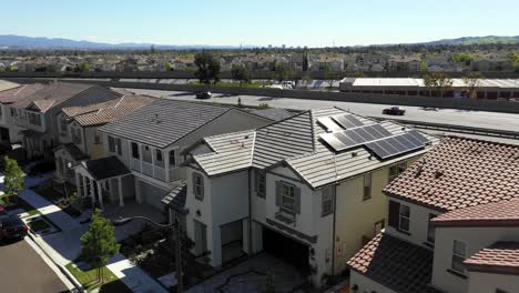 Solar-panels-on-Tustin-home,-freeway-behind-house,-orbit-clean-energy-on-sunny-day