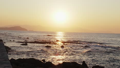 Zeitlupenaufnahme-Des-Sonnenuntergangs-über-Meereswellen,-Die-Gegen-Steine-Krachen,-Schöner-ägäischer-Meerhintergrund-In-Chania,-Kreta-Griechenland