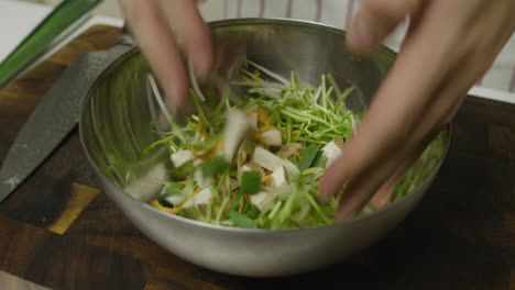 Mixing-green-veggies-in-metal-cooking-bowl