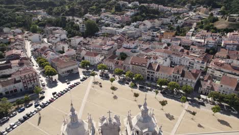 Aerial-pull-out-shot-overlooking-at-the-cityscape-in-front-of-Alcobaça-monastery,-Portugal