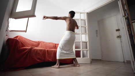 Bachelor-dancing-alone-semi-nude-in-towel-at-apartment