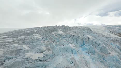 Aerial-flight-over-gigantic-iced-glacier-landscape-in-Buarbreen,-Norway-during-cloudy-day