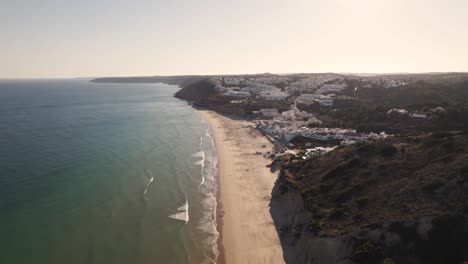 Paradisiac-long-strip-of-sand-and-calming-ocean-waves,-Salema-beach,-Algarve,-Aerial-view