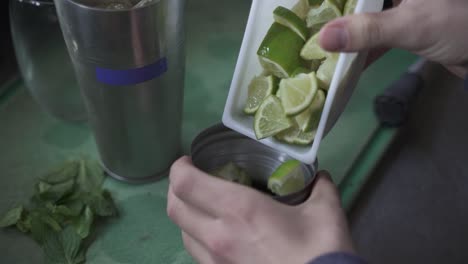 Unrecognizable-bartender-adding-lime-slices-in-cynar-drink