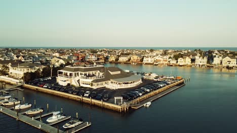 Ariel-of-harborfront-restaurant-in-Stone-Harbor,-New-Jersey-during-golden-hour