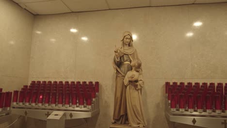 Votiv-Gebetskerzen,-Die-Eine-Statue-Der-Jungfrau-Maria-Umgeben