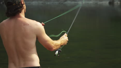Fly-fishing,-a-man-gets-his-line-tangled-around-the-rod-whilst-fly-casting-during-a-camping-trip-to-Glacier-National-Park