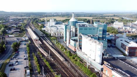 Industrial-chemical-manufacturing-factory-next-to-Warrington-Bank-Quay-train-tracks-aerial-view-rising-shot