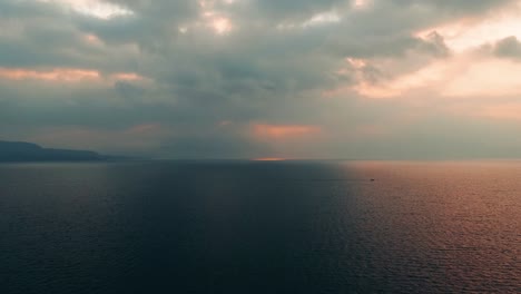 Flying-over-the-calm-sunset-waves-of-Casa-Palopo,-Guatemala--Time-lapse