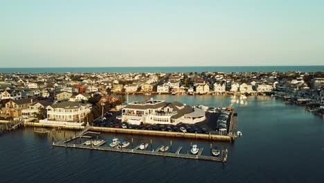 Drone-shot-circling-a-restaurant-sitting-harborfront-in-Stone-Harbor,-New-Jersey