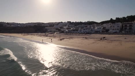 Coastline-of-Salema-beach-bounded-by-white-seaside-townhouses,-Algarve