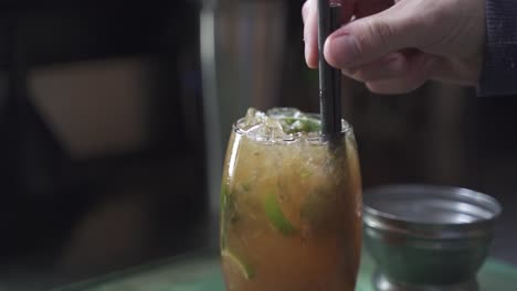 Slow-motion-shot-of-person-putting-straw-in-Tasty-Cynar-Drink,close-up