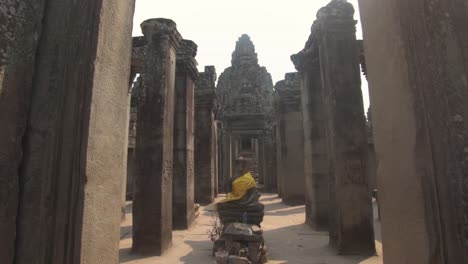 Buddha-statue-at-ancient-Bayon-Khmer-temple-in-Angkor-Thom,-Cambodia,-pull-out-shot