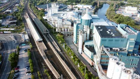 Industrial-chemical-manufacturing-factory-next-to-Warrington-Bank-Quay-train-tracks-aerial-view-fly-over-tilt-down