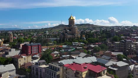 Aerial:-Tbilisi-city-reveal,-Metekhi-Church-in-background,-Georgia-capital