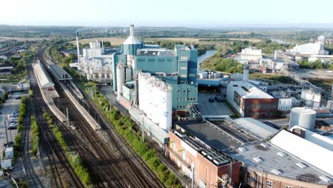 Industrial-chemical-manufacturing-factory-next-to-Warrington-Bank-Quay-train-tracks-aerial-view-rising-up