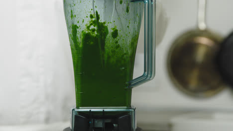 Mixer-mixing-fresh-healthy-smoothie-with-spinach-and-vegetables,close-up-slow-motion