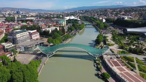 Aerial:-Tbilisi-bridge-modern-architecture-in-Georgia,-iconic-Bridge-of-Peace