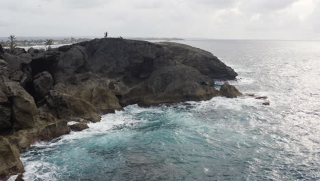 Ocean-Waves-Crashing-Against-Rocky-Cliffs-At-Cueva-del-Indio,-Las-Piedras,-Puerto-Rico---aerial-drone-shot