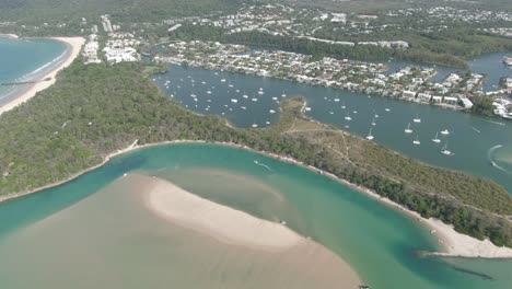 Aerial:-Footage-of-Noosa-lagoon-with-beautiful-clear-emerald-water-that-flows-down-from-the-larger-estuary-system-into-the-beach