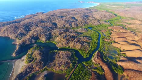 Blick-Aus-Der-Vogelperspektive-Auf-Die-Mündung-Des-Mangrovenflusses-In-Der-Nähe-Des-Meeresrandes-Mit-Braunen-Wüstenhügeln