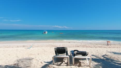 Wunderschöne,-Hochkippende-Aufnahme-Eines-Tropischen-Strandes-Mit-Schwimmenden-Touristen-Und-Einem-Kleinen-Boot-Neben-Ihnen-An-Der-Wunderschönen-Playa-Del-Carmen-An-Der-Riviera-Maya,-Mexiko,-In-Der-Nähe-Von-Cancun-An-Einem-Sommertag-Im-Urlaub