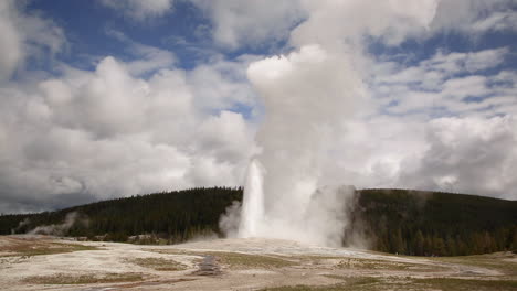 Viejo-Fiel-Géiser-Parque-Nacional-De-Yellowstone-En-Erupción-Cielo-Azul