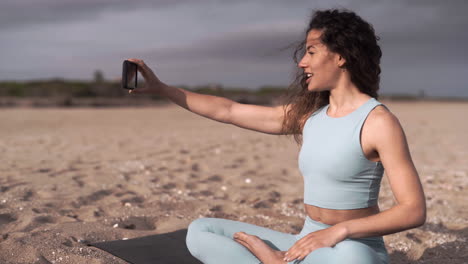 Calming-yogi-teaching-on-a-video-call-at-Mallorca-beach-Spain