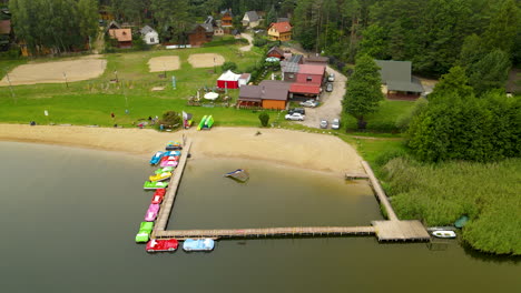 Car-Shape-Paddle-Boats-In-The-Lake-With-Rental-Cabins-On-The-Lakeshore-In-Hartowiec,-Poland
