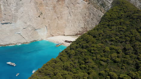 Aerial-View-Of-Tourists-And-Boats-In-Navagio-Beach-With-Shipwreck-On-A-Sunny-Summer-Day-In-Greece