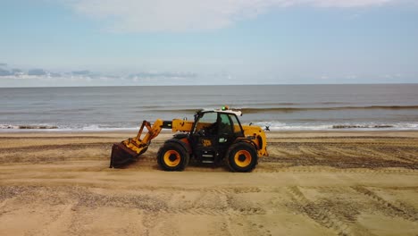 Aerial-Drone-Footage-of-a-Digger-Working-On-Gorleston-On-Sea-Beach,-Norfolk
