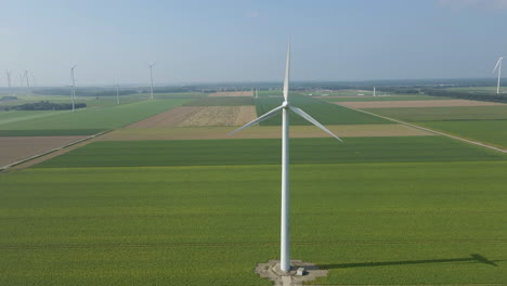 Jib-up-of-spinning-wind-turbine-in-a-large-windmill-park-in-green-meadows