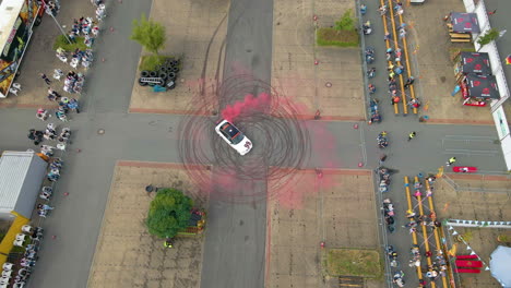 Aerial-View-Of-Sports-Car-Drifting-In-Circle-With-Red-Smoke-And-Tire-Tracks
