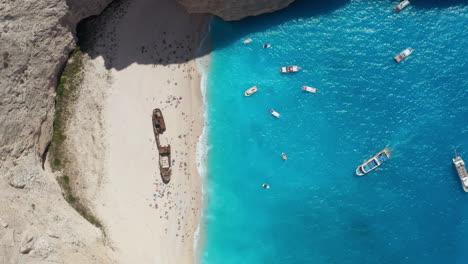 Famous-Navagio-Beach-With-Shipwreck---Boats-Floating-On-Turquoise-Water-Of-Coast-Of-Zakynthos-In-Greece