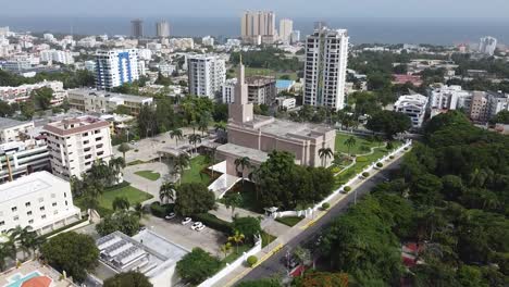 drone-flight-in-the-city-approaching-the-santo-domingo-temple,-beautiful-landscape-of-the-metropolitan-area-with-background-of-tall-buildings