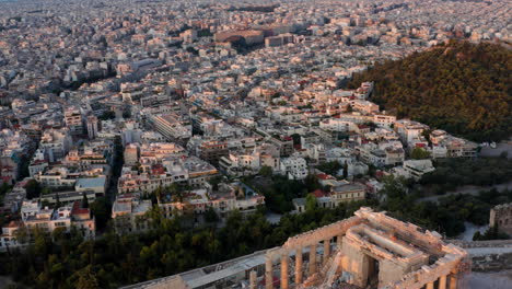 Aerial-View-Of-Buildings-In-Athens-City-With-Historic-Parthenon-Temple-At-Acropolis-of-Athens-In-Greece
