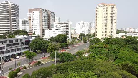 Drone-flying-over-santo-domingo-iberoamerican-park-with-views-of-tall-buildings-in-the-background,-upper-middle-class-residential-area