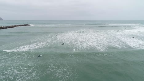 Aerial-shot-of-surfers-in-Lima-during-wintertime