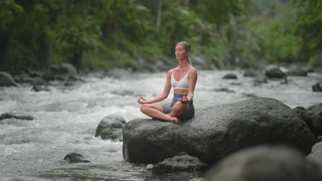 Woman-unwinding-from-busy-life-in-nature,-sitting-in-easy-pose-with-hands-Gyan-Mudra