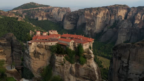 Aerial-View-Of-Varlaam-Monastery-Atop-A-Cliff-During-Sunset-In-Meteora,-Greece