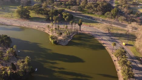 Aerial-shot-of-beautiful-natural-Lake-in-Buenos-Aires-and-many-people-doing-sport-activity-and-walking-around---Sunset-light-vibes-in-the-evening