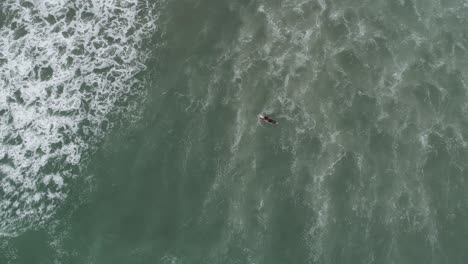 Zenith-POV-of-surfer-paddling-through-wave