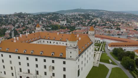 Orbiting-Aerial-Shot-Above-Bratislava-Castle-Reveals-Cityscape-in-Background