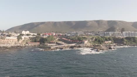 Seascape-With-Scenic-Mountains-And-Coastal-Neighborhood-In-South-Africa---aerial-drone-shot