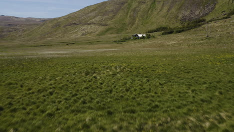 Grass-Field-Meadow-with-Isolated-House-in-Iceland-Landscape---Aerial-Flight