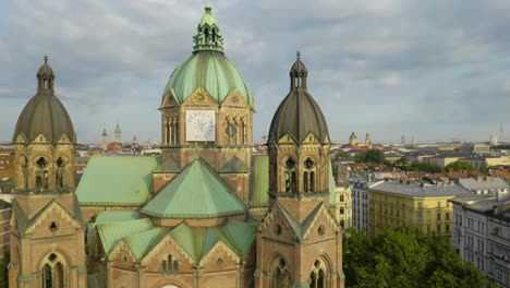 Cinematic-Aerial-Shot-of-Drone-Circling-in-Front-of-St-Luke's-Church-in-Munich,-Germany
