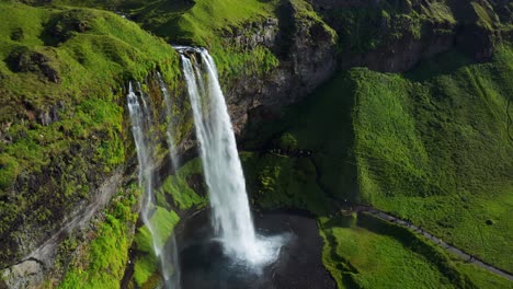 Vista-Aérea-De-La-Cascada-Seljalandsfoss-Con-Naturaleza-Verde,-Popular-Atracción-Turística-En-Islandia