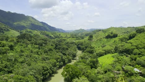Drone-aerial-footage-of-river-Rio-Cahabon-near-Semuc-Champey-National-Park-in-Guatemala-surrounded-by-bright-green-rainforest-trees-on-a-cloudy-day