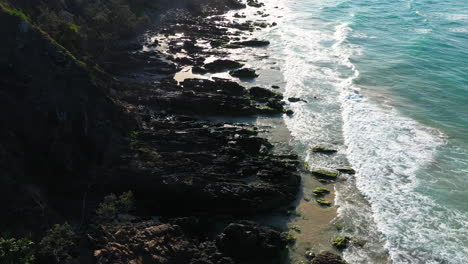 4k-Aerial-shot-of-a-rocky-surf-beach-at-Byron-Bay,-Australia